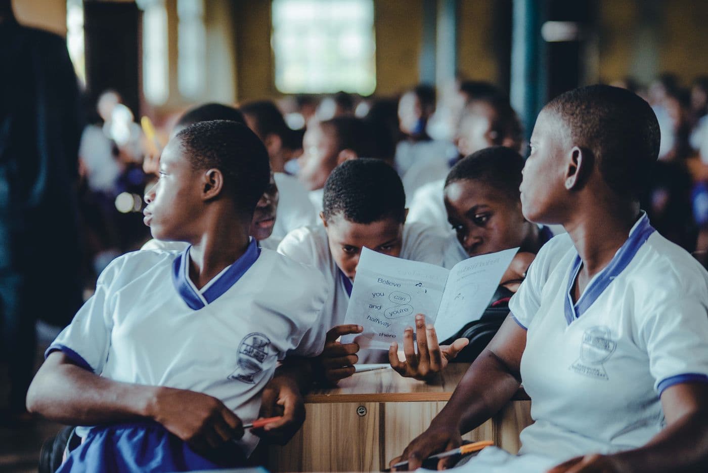 Students in school uniform working together in a classroom.