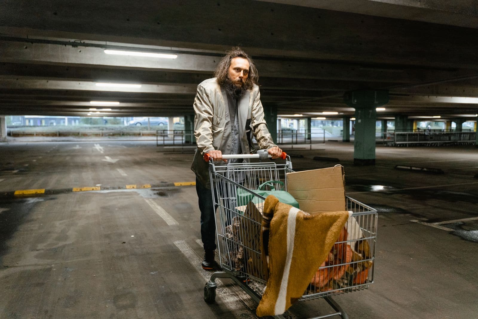 A man pushing a cart carrying his belongings.